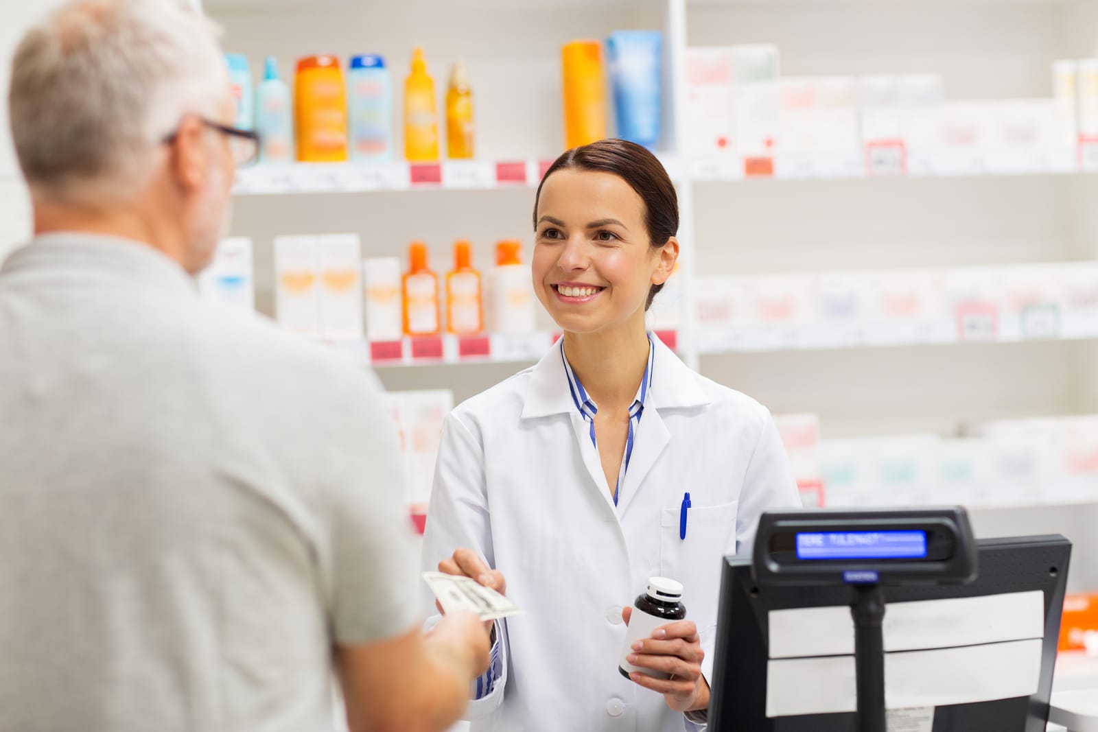 medicine, pharmaceutics, health care and people concept - apothecary and senior man customer buying drug at drugstore