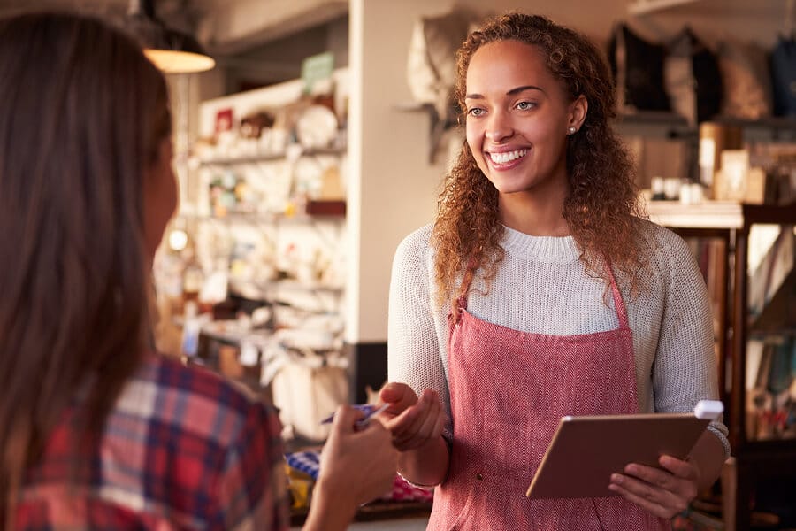 Sales Assistant With Credit Card Reader On Digital Tablet