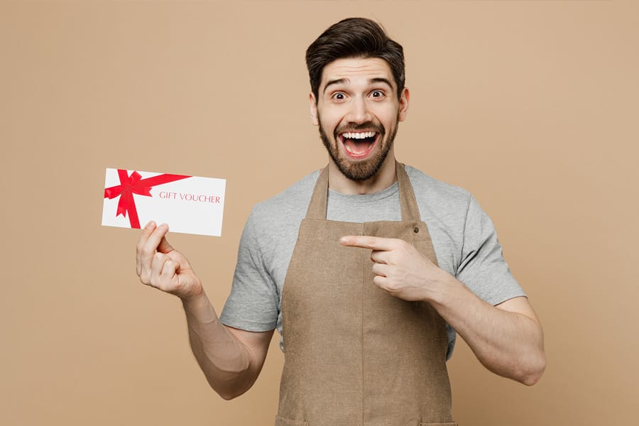 Young man employee pointing finger at gift card software coupon