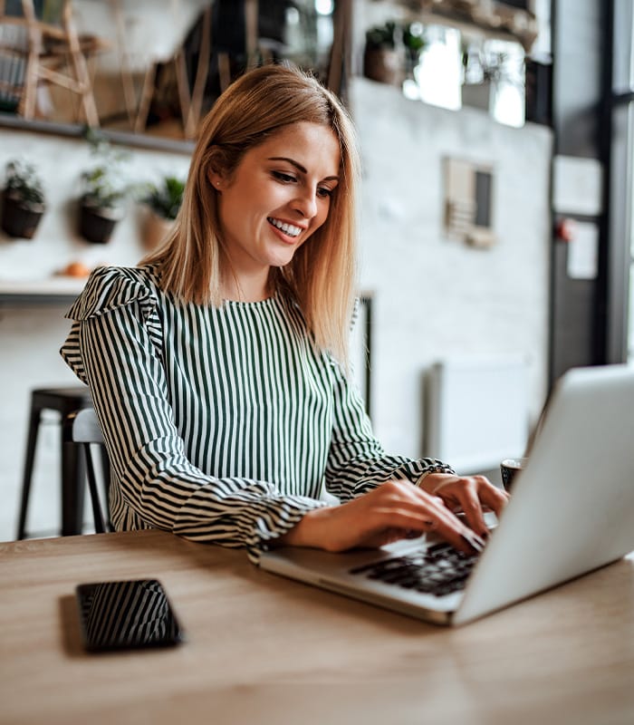 Woman smiling while working on laptop