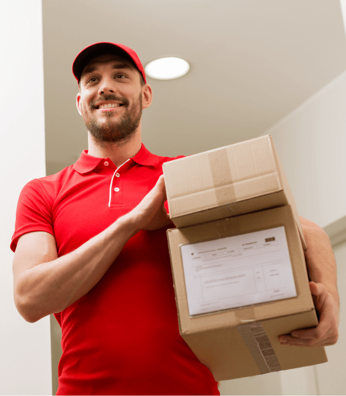 A cheerful delivery person in a bright red uniform holding packages, ready to provide exceptional service. This image highlights reliable and efficient delivery services that bring convenience straight to your doorstep with delivery software.